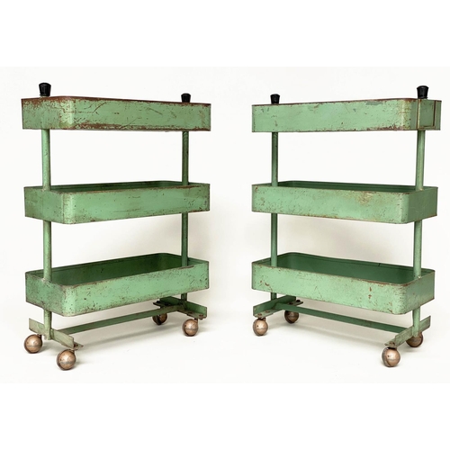 219 - WORKSHOP TROLLEYS, a pair, mid 20th century original green painted metal each with three tiers (on c... 