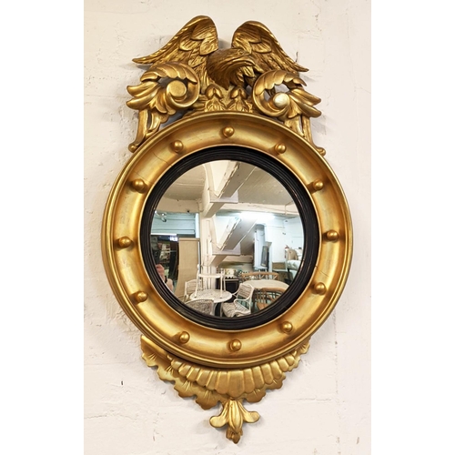 241 - CONVEX MIRROR, 19th century giltwood, carved eagles crest above a convex plate with an ebony reeded ... 