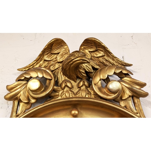 241 - CONVEX MIRROR, 19th century giltwood, carved eagles crest above a convex plate with an ebony reeded ... 