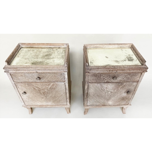 254 - BEDSIDE CHESTS, a pair, mid 20th century limed oak each galleried with mirror top, drawer and cupboa... 