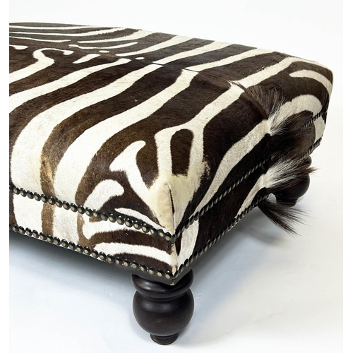 326 - ZEBRA SKIN FOOTSTOOL, rectangular studded zebra hide upholstered on turned wooden supports, 43cm H x... 