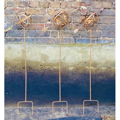 443 - ARMILLARY SPHERE GARDEN STAKES, a set of three, 115cm H x 39cm W x 17cm D, coppered metal finish. (3... 