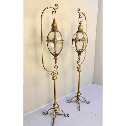 470 - STORM LANTERNS ON STANDS, a pair, 163cm high, 35cm wide, Regency style, gilt metal. (2)