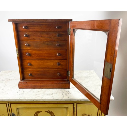 16 - COLLECTORS CABINET, Victorian mahogany with six graduated drawers behind arched glazed door on plint... 