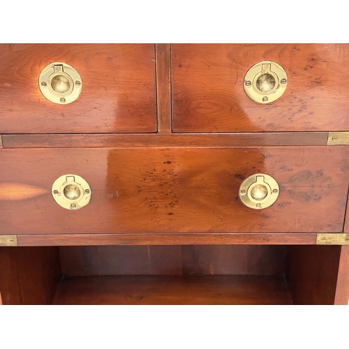 135 - CAMPAIGN STYLE CHESTS, a pair, yewwood and brass bound each with tooled leather brushing slide and t... 