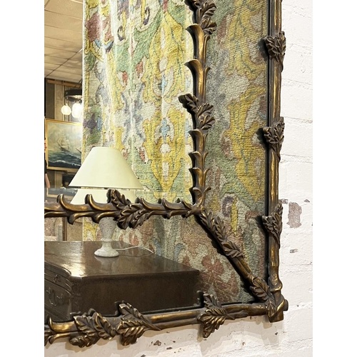 166 - WALL MIRROR, French style oak leaf decorated gilt frame with aged marginal plates, 154cm x 104cm.