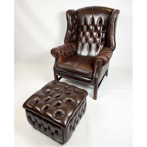 169 - WING ARMCHAIR, deep buttoned brown leather, with brass stud work and stretchered legs with buttoned ... 