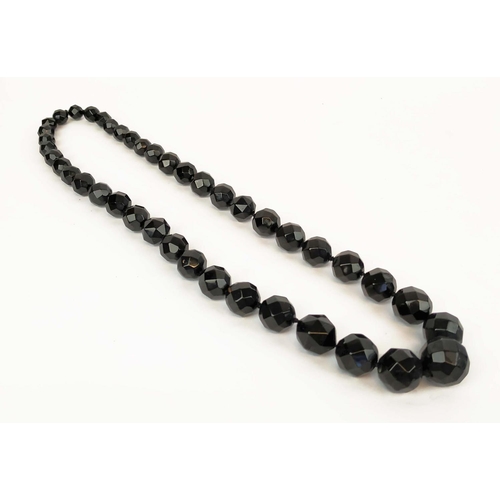 35 - A WHITBY JET SINGLE STRAND NECKLACE, fitted with 42 graduated faceted beads, 74cm long; together wit... 