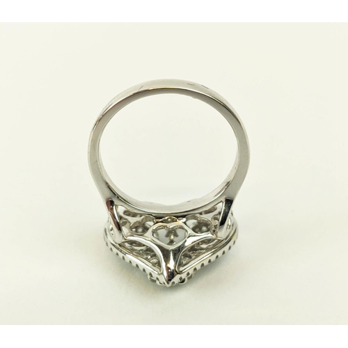 11 - AN 18CT WHITE GOLD DIAMOND DRESS RING, the head in the form of a heart, encrusted with round brillia... 