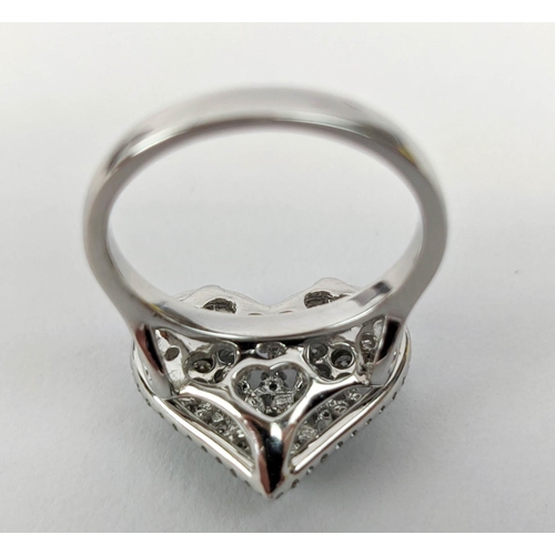 11 - AN 18CT WHITE GOLD DIAMOND DRESS RING, the head in the form of a heart, encrusted with round brillia... 