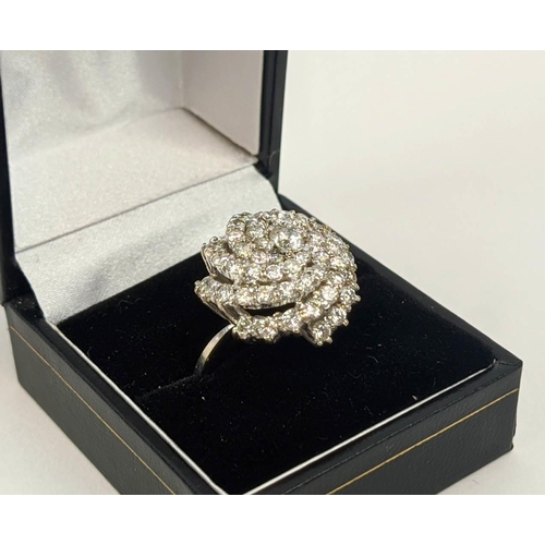 12 - AN 18CT WHITE GOLD DIAMOND SET DRESS RING, of spiral design, the central stone of approximately 0.33... 