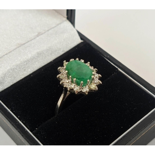 13 - AN 18CT WHITE GOLD EMERALD AND DIAMOND DRESS RING, the central claw set emerald with an approximate ... 