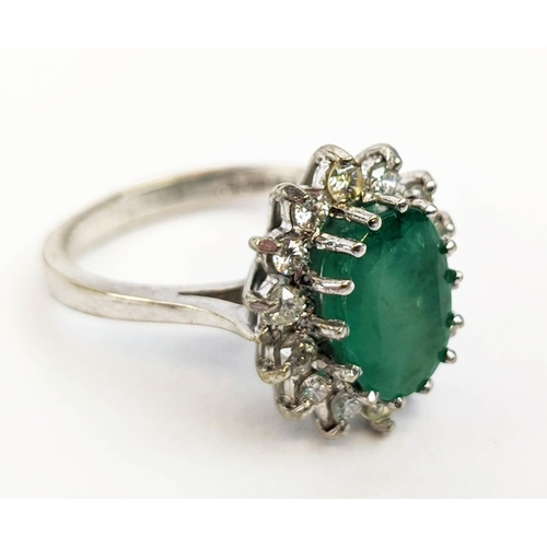 13 - AN 18CT WHITE GOLD EMERALD AND DIAMOND DRESS RING, the central claw set emerald with an approximate ... 
