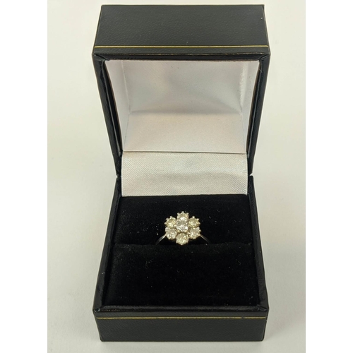 7 - AN 18CT WHITE GOLD DIAMOND FLOWER HEAD SEVEN STONE CLUSTER RING, the central brilliant cut stone of ... 