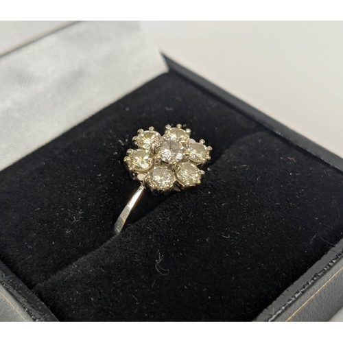 7 - AN 18CT WHITE GOLD DIAMOND FLOWER HEAD SEVEN STONE CLUSTER RING, the central brilliant cut stone of ... 