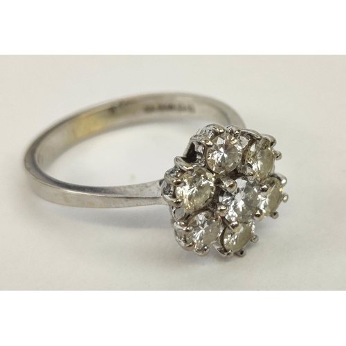 7 - AN 18CT WHITE GOLD DIAMOND FLOWER HEAD SEVEN STONE CLUSTER RING, the central brilliant cut stone of ... 