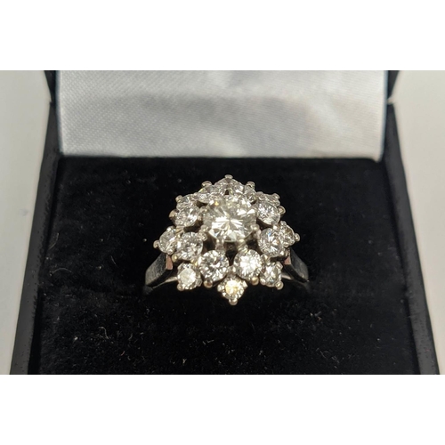 9 - AN 18CT WHITE GOLD AND PLATINUM DIAMOND SET FLOWER HEAD CLUSTER RING, the central round brilliant cu... 