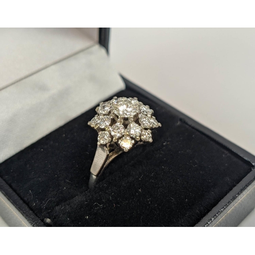 9 - AN 18CT WHITE GOLD AND PLATINUM DIAMOND SET FLOWER HEAD CLUSTER RING, the central round brilliant cu... 