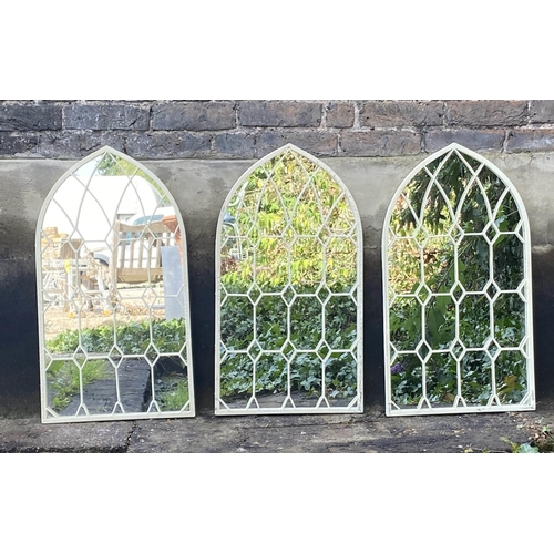 472 - ARCHITECTURAL GARDEN WALL MIRRORS, a set of three, aged white painted frames, 76cm x 42cm. (3)