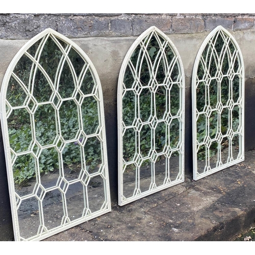 472 - ARCHITECTURAL GARDEN WALL MIRRORS, a set of three, aged white painted frames, 76cm x 42cm. (3)