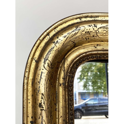 111 - OVERMANTEL MIRROR, 19th century French arched giltwood and composition incised moulded and beaded fr... 