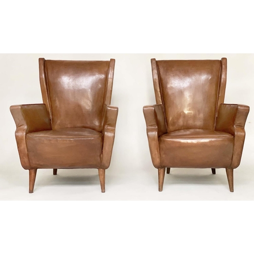 287 - WING ARMCHAIRS, a pair, 1950s Italian mid brown leather, with slightly splayed leather clad supports... 