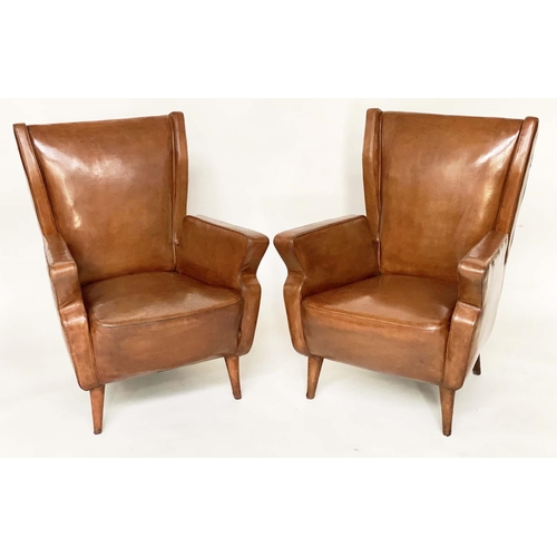 287 - WING ARMCHAIRS, a pair, 1950s Italian mid brown leather, with slightly splayed leather clad supports... 