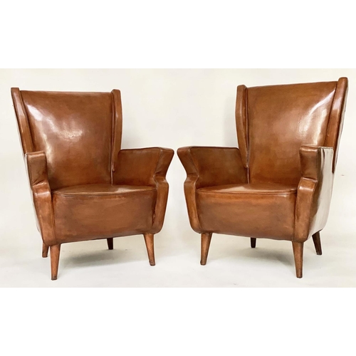 287 - WING ARMCHAIRS, a pair, 1950s Italian mid brown leather, with slightly splayed leather clad supports... 