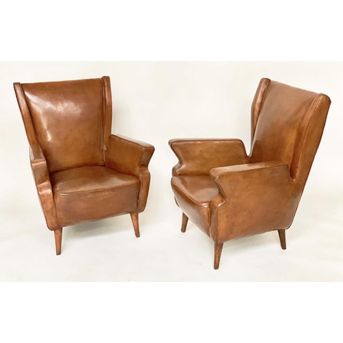 287 - WING ARMCHAIRS, a pair, 1950s Italian mid brown leather, with slightly splayed leather clad supports... 