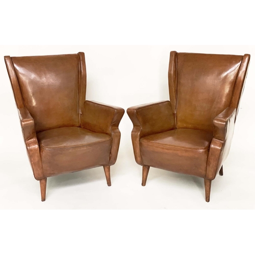 287 - WING ARMCHAIRS, a pair, 1950s Italian mid brown leather, with slightly splayed leather clad supports... 