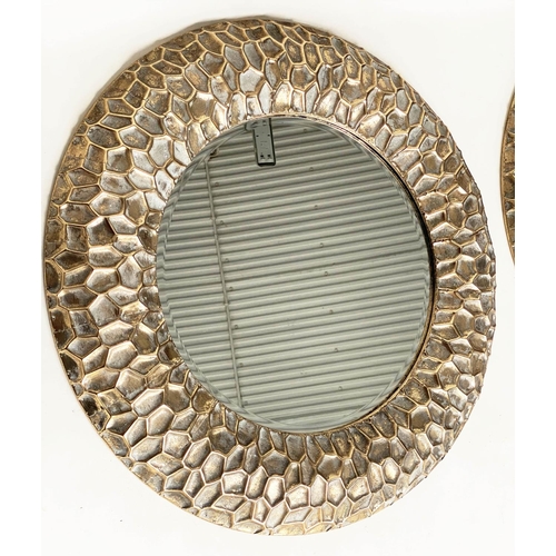 291 - CIRCULAR WALL MIRRORS, a pair, with 'hammered' cushion gilt metal frames, 73cm W. (2)