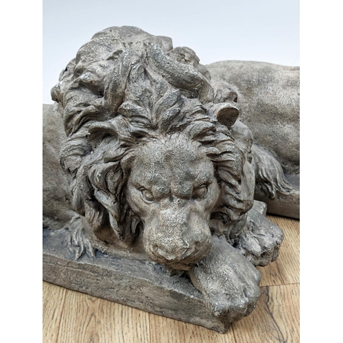 519 - SCULPTURAL RECUMBENT LIONS, a pair, 52cm x 22cm x 30cm, resin, faux stone finish. (2)