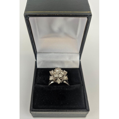 23 - AN 18CT WHITE GOLD DIAMOND FLOWER HEAD COCKTAIL RING, with a central stone of approximately 0.25 car... 