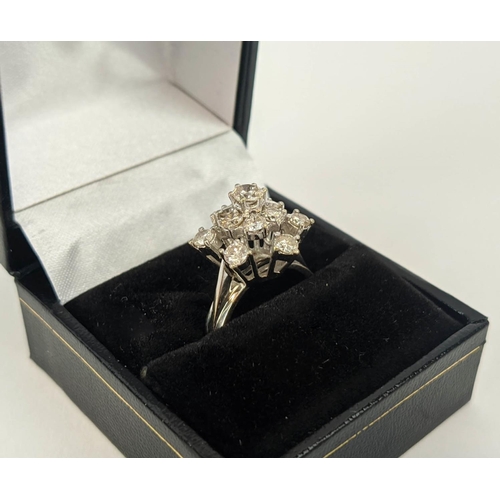 23 - AN 18CT WHITE GOLD DIAMOND FLOWER HEAD COCKTAIL RING, with a central stone of approximately 0.25 car... 