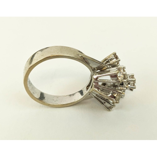 23 - AN 18CT WHITE GOLD DIAMOND FLOWER HEAD COCKTAIL RING, with a central stone of approximately 0.25 car... 