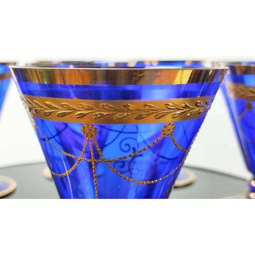 30 - A SET OF VENETIAN COBALT BLUE AND GOLD HAND PAINTED GLASSES, seven champagne coupes, nine martini gl... 