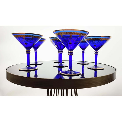 30 - A SET OF VENETIAN COBALT BLUE AND GOLD HAND PAINTED GLASSES, seven champagne coupes, nine martini gl... 