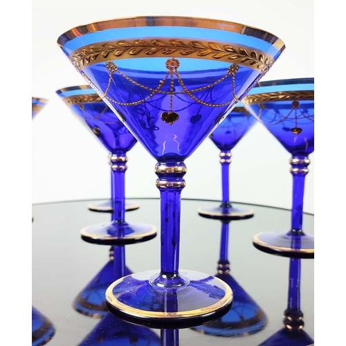 30 - A SET OF VENETIAN COBALT BLUE AND GOLD HAND PAINTED GLASSES, seven champagne coupes, nine martini gl... 