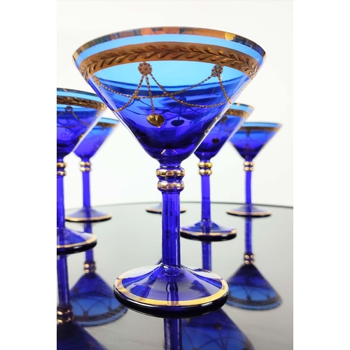 30 - A SET OF VENETIAN COBALT BLUE AND GOLD HAND PAINTED GLASSES, seven champagne coupes, nine martini gl... 