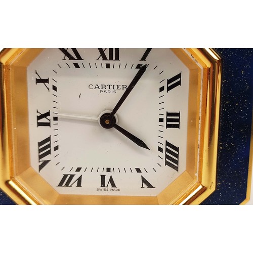 65 - A CARTIER TRAVELLING CLOCK, simulated lapis lazuli enameled gilt octagonal case, white dial with Rom... 