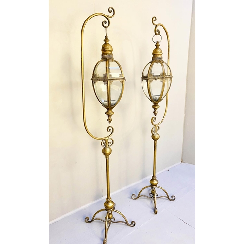 362 - STORM LANTERNS ON STANDS, a pair, 163cm high, 35cm wide, 30cm deep, Regency style, gilt metal. (2)