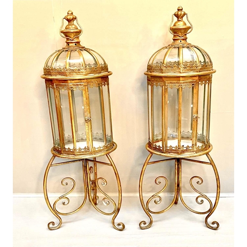 329 - STORM LANTERNS ON STANDS, 115cm H x 34cm diam., Regency style, gilt metal frames. (2)