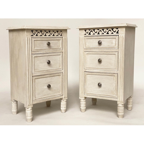 114 - BEDSIDE CHESTS, a pair, French style grey painted each with three drawers and pierced frieze, 40cm x... 