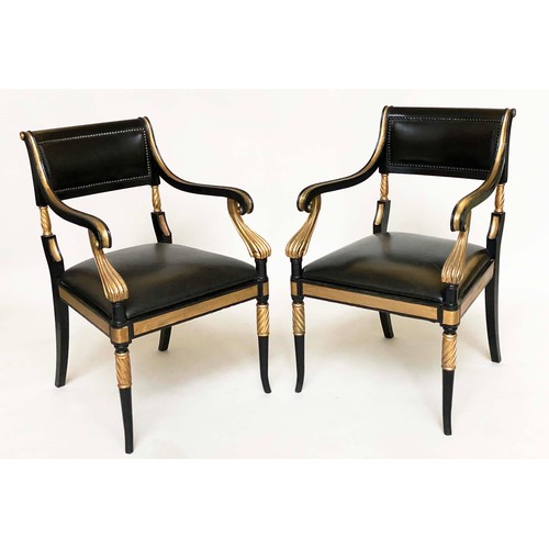 149 - ARMCHAIRS, a pair, Regency style lacquered and gilded with leather seats, scroll arms and swept supp... 