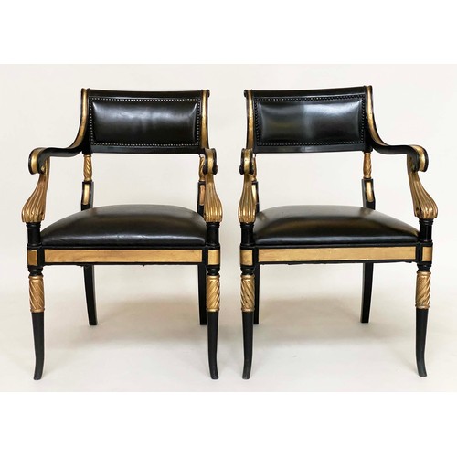 149 - ARMCHAIRS, a pair, Regency style lacquered and gilded with leather seats, scroll arms and swept supp... 