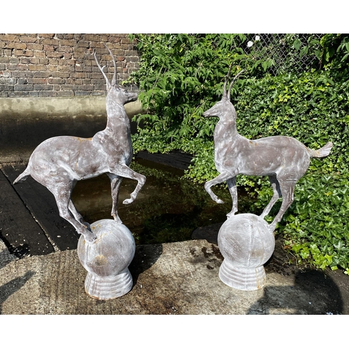 457 - SCULPTURAL STAGS, a pair, 100cm high, 60cm wide, cast metal, on globular bases. (2)