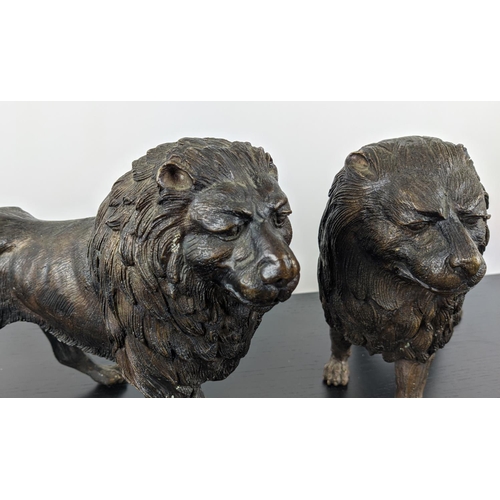 474 - CONTEMPORARY SCHOOL SCULPTURAL LIONS, a pair, cast metal, 45cm x 10cm x 25cm each. (2)