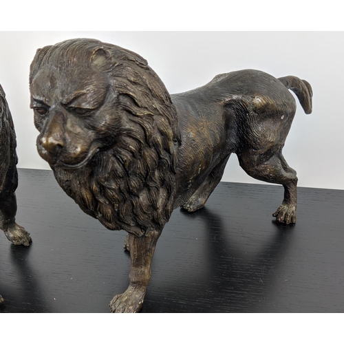 474 - CONTEMPORARY SCHOOL SCULPTURAL LIONS, a pair, cast metal, 45cm x 10cm x 25cm each. (2)