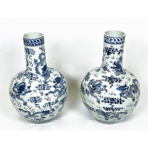 42 - CHINESE BLUE AND WHITE VASES, a pair, painted with dragons chasing the flaming pearl of wisdom, 63cm... 
