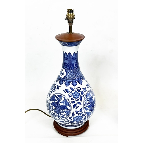 44 - CHINESE BOTTLE LAMPS, a pair, blue and white with scrolling foliate and phoenix decoration, 56cm H. ... 